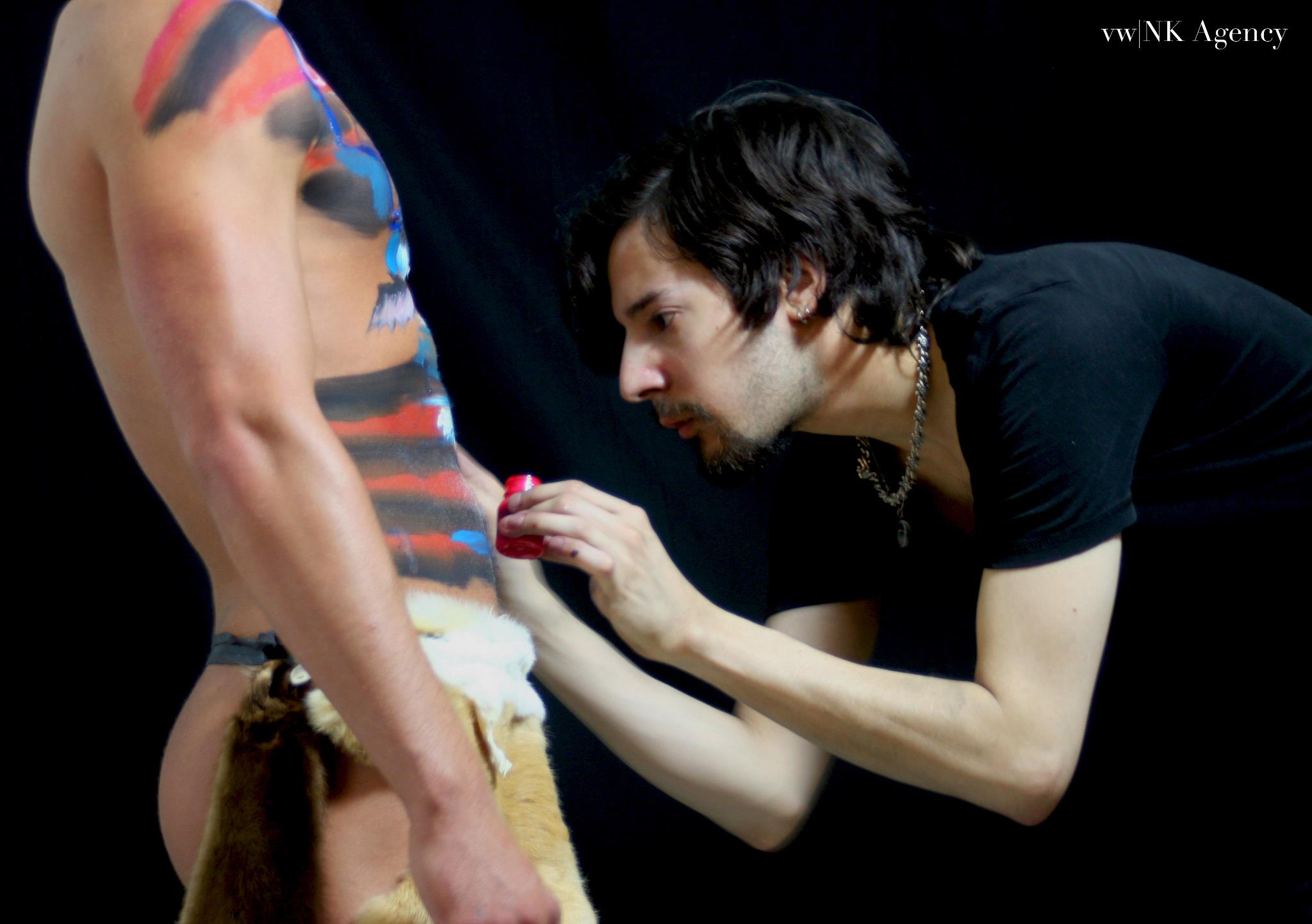 Zander body painting a male model.